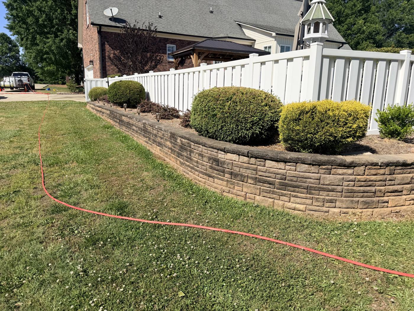Retaining wall stained dark with algae and mildew before cleaning