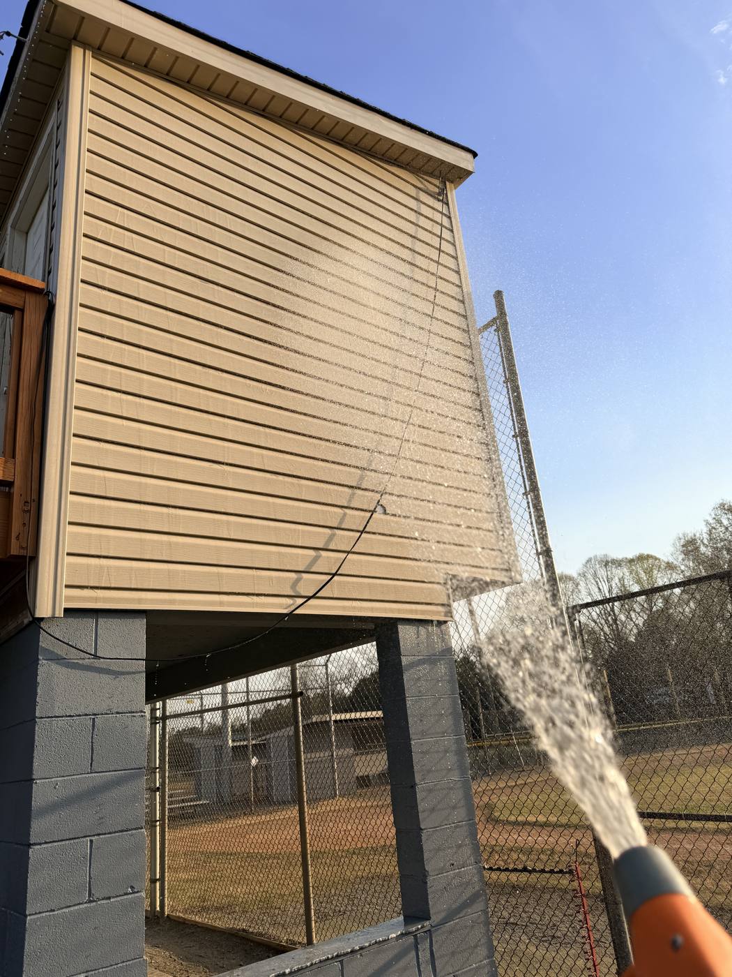 Soft washing siding with a pressure washer wand
